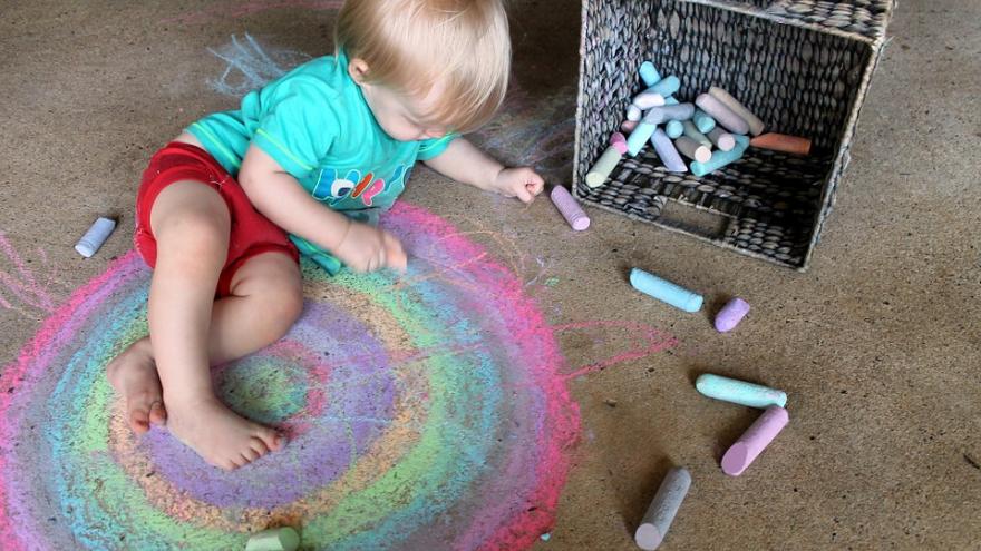 Niño pintando con tizas.