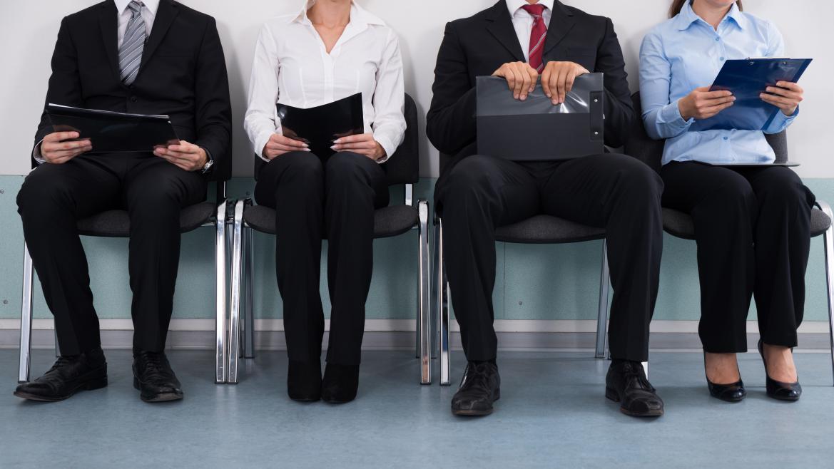 Cuatro personas sentadas esperando en entrevista de trabajo