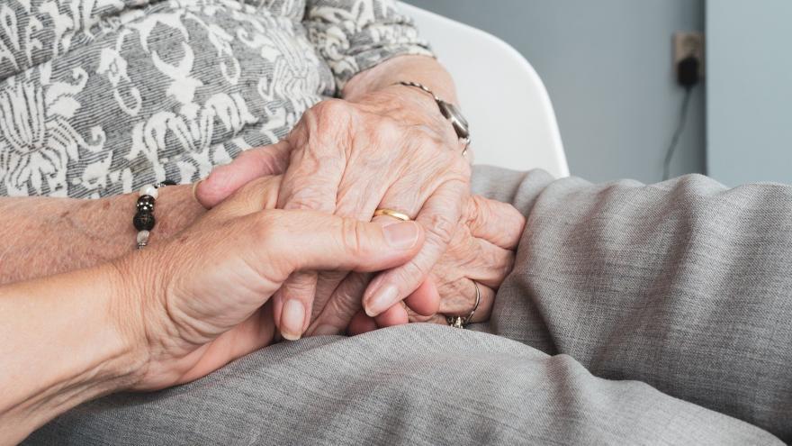 dependencia Sujetando las manos a un anciano