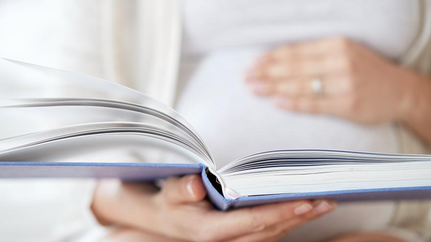 La mano de una persona sostiene un libro abierto