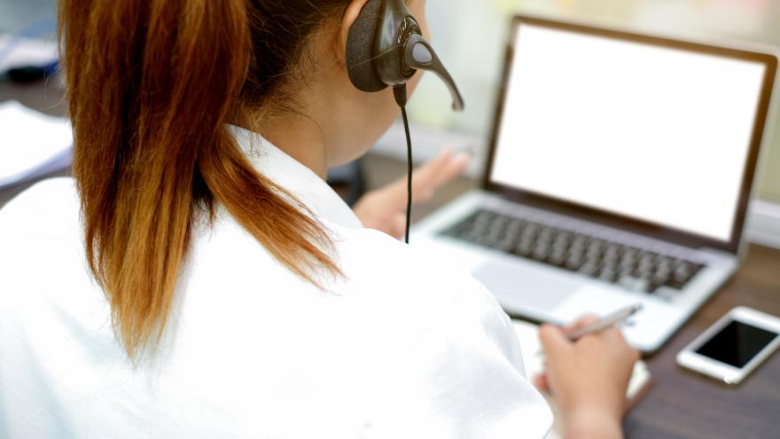 Mujer de espaldas atendiendo el teléfono